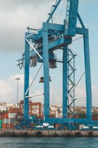 Contemporary dockside cargo crane located on industrial embankment in port on clear day