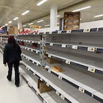 Person Walking on Empty Aisle on Grocery Store